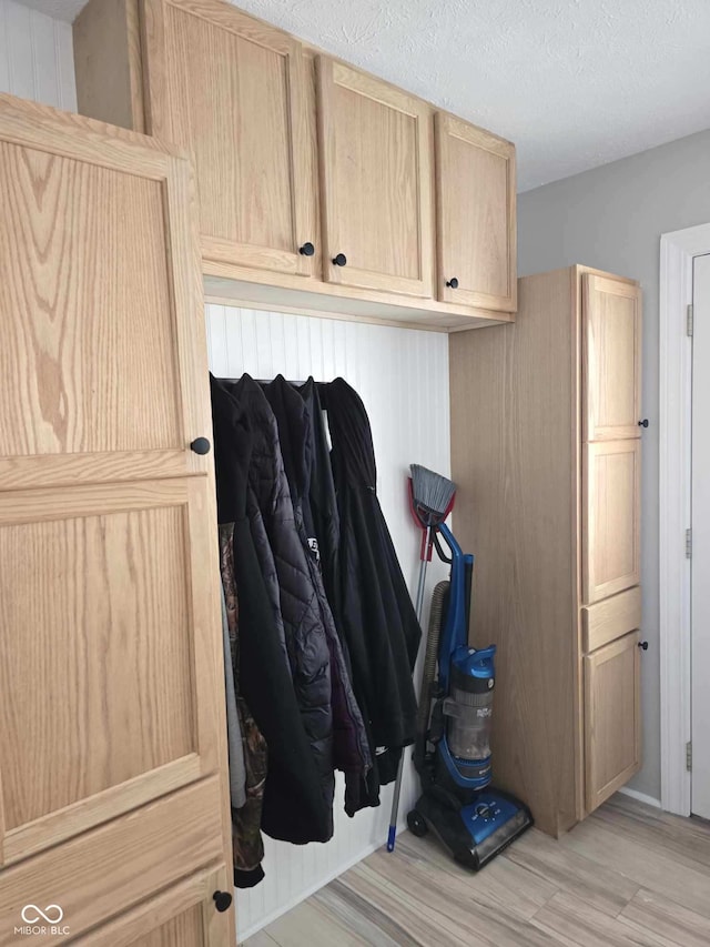 mudroom with light wood-style flooring and a textured ceiling