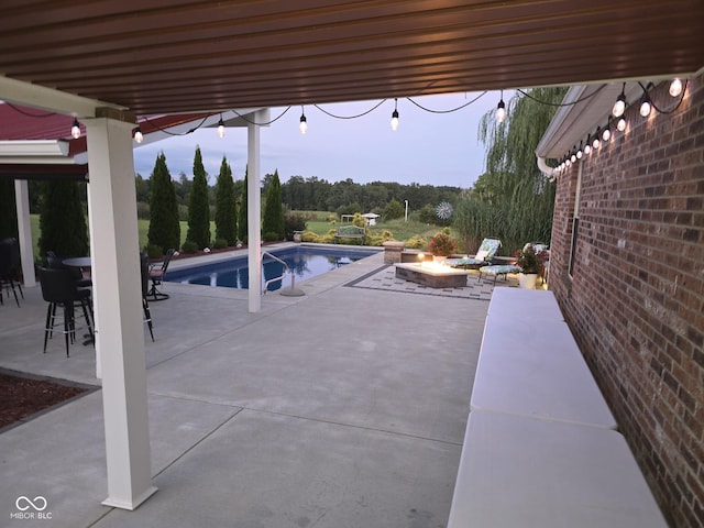 view of patio / terrace featuring an outdoor pool and a fire pit