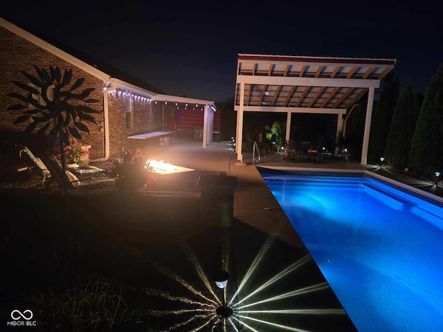 pool at night with a patio, an outdoor pool, and a pergola