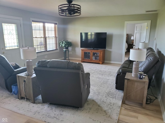 living area with wood finished floors, visible vents, and baseboards