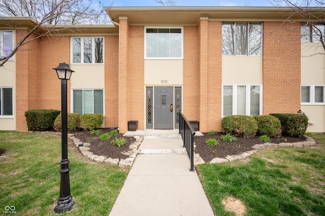 exterior space featuring a lawn and brick siding