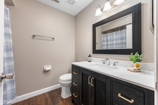 full bathroom with visible vents, baseboards, toilet, wood finished floors, and vanity