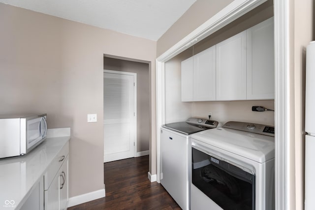 laundry area featuring cabinet space, baseboards, dark wood-style floors, and washer and clothes dryer