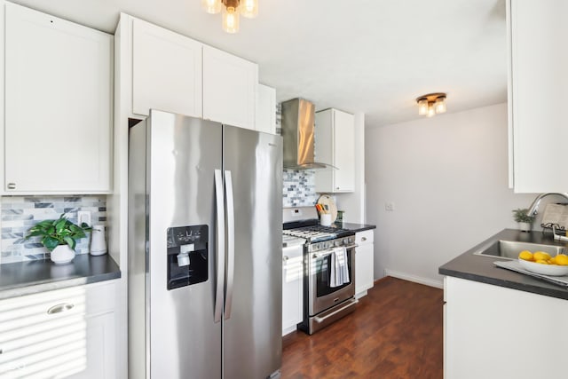 kitchen featuring a sink, backsplash, dark countertops, appliances with stainless steel finishes, and wall chimney exhaust hood