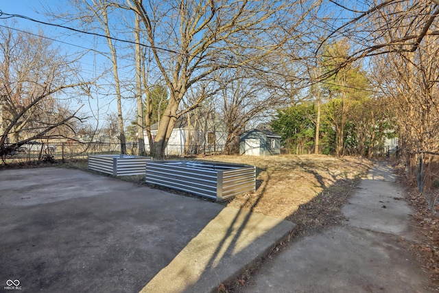 view of yard with an outbuilding, fence, and a shed