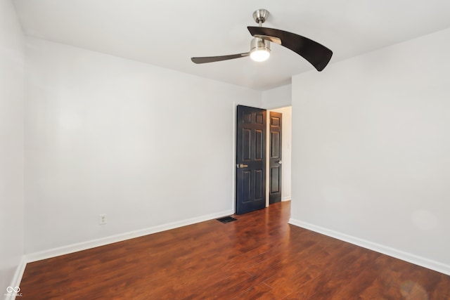 empty room with visible vents, wood finished floors, baseboards, and ceiling fan