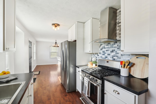 kitchen featuring decorative backsplash, dark countertops, wall chimney exhaust hood, and stainless steel appliances