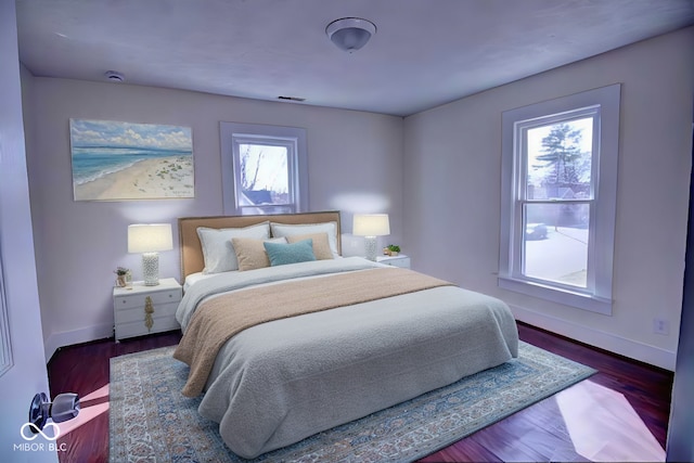 bedroom featuring baseboards and dark wood-style flooring