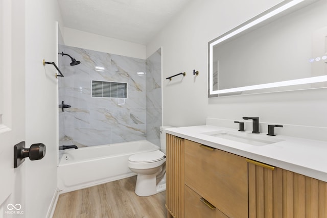 full bath featuring toilet, a textured ceiling, wood finished floors, bathtub / shower combination, and vanity