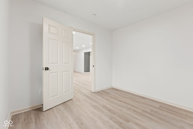 unfurnished room featuring baseboards and light wood finished floors