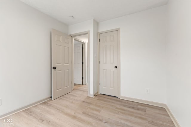 unfurnished bedroom featuring light wood-style flooring and baseboards