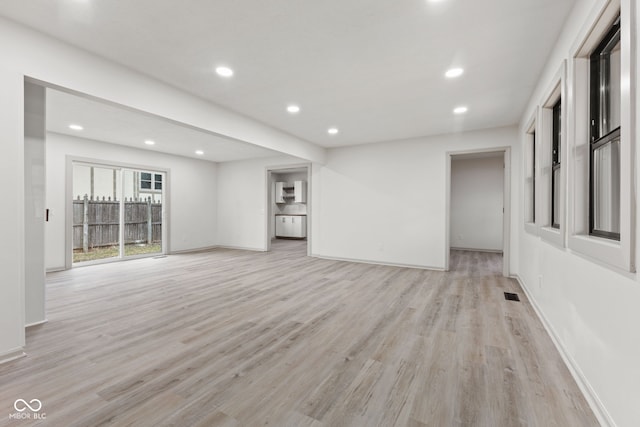 empty room with light wood-style flooring, recessed lighting, visible vents, and baseboards