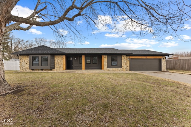 view of front of home with a garage, stone siding, a front lawn, and fence