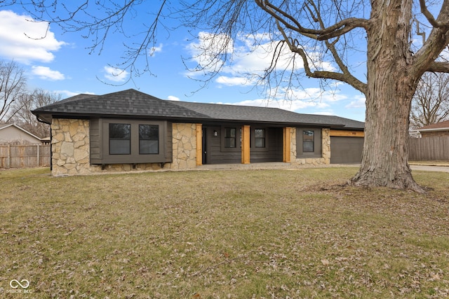 view of front of home featuring stone siding, a front lawn, an attached garage, and fence