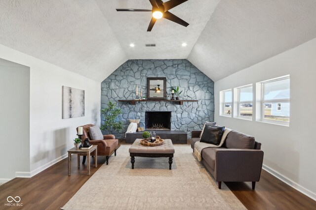 living room with wood finished floors, a ceiling fan, lofted ceiling, and a textured ceiling