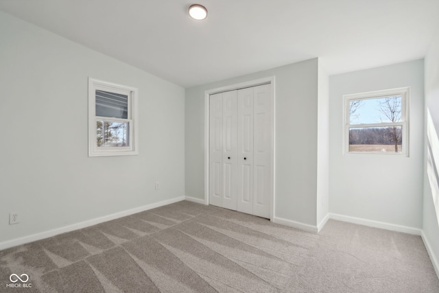 unfurnished bedroom featuring a closet, carpet flooring, and baseboards