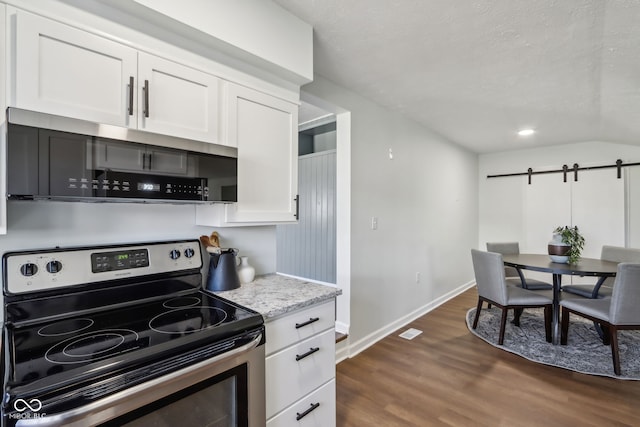 kitchen with baseboards, stainless steel electric stove, dark wood-style flooring, white cabinets, and a barn door