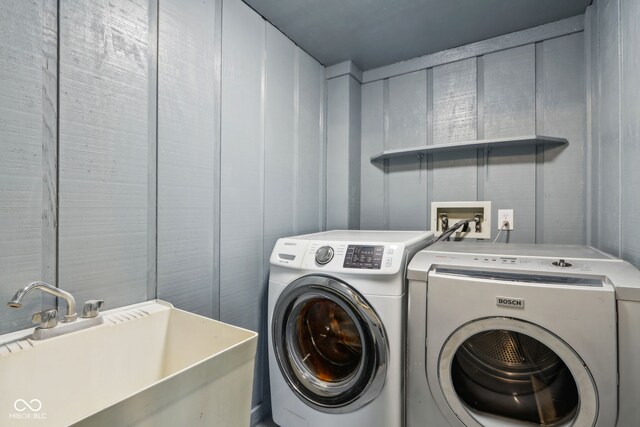 clothes washing area featuring a sink, independent washer and dryer, and laundry area