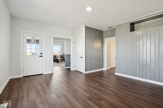 interior space featuring baseboards, dark wood-style flooring, and a textured ceiling