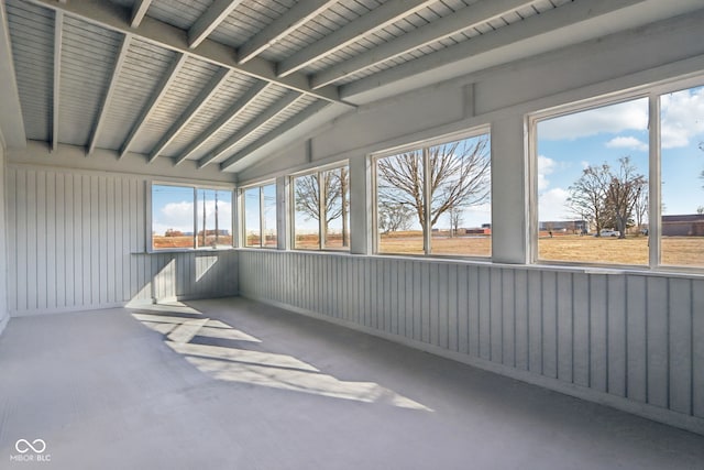 unfurnished sunroom with vaulted ceiling with beams