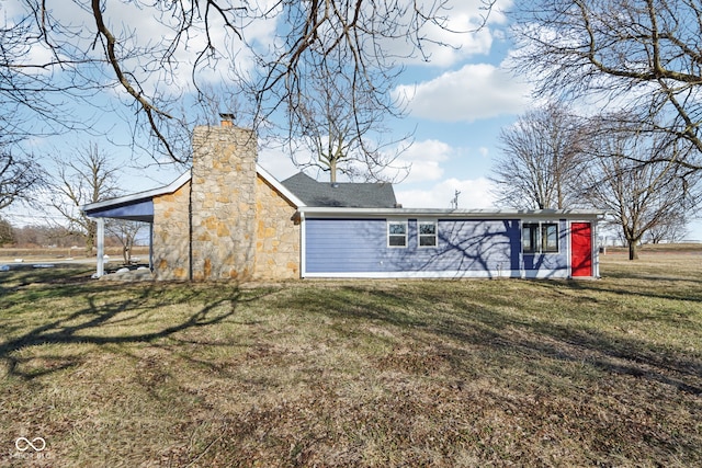 rear view of property featuring a yard and a chimney