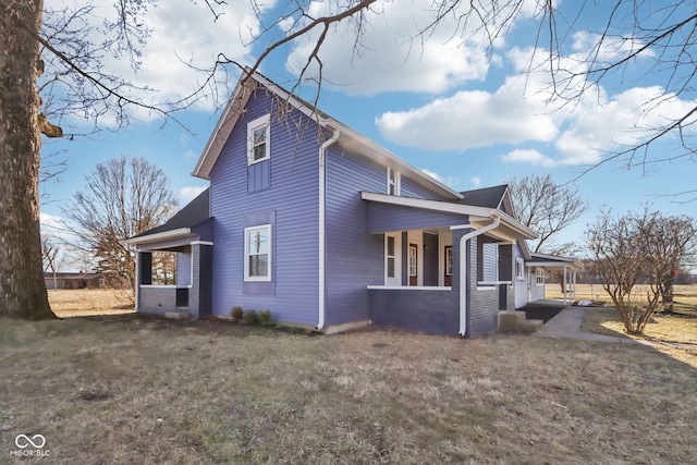 view of side of property featuring a yard and brick siding