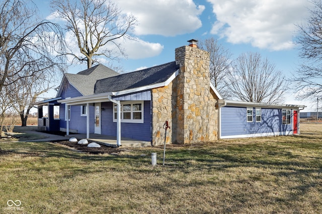 exterior space with a yard, roof with shingles, and a chimney