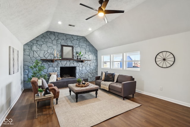 living area featuring lofted ceiling, wood finished floors, visible vents, and a textured ceiling