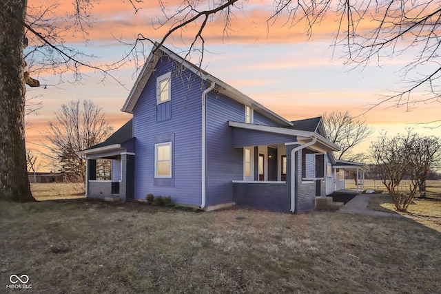 view of side of home featuring a yard and brick siding