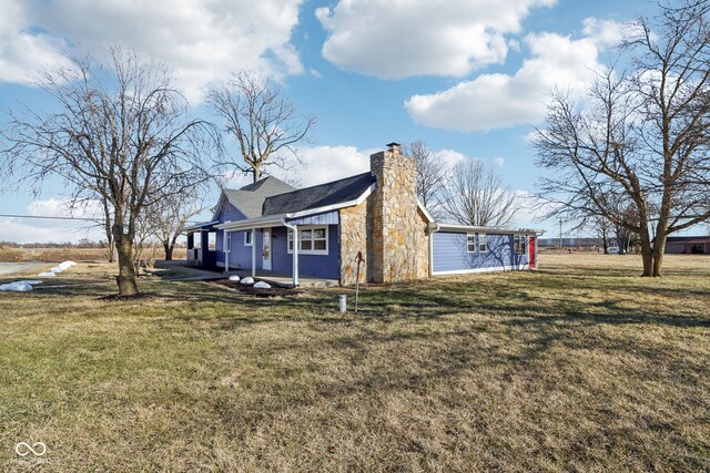 view of side of property featuring a lawn and a chimney