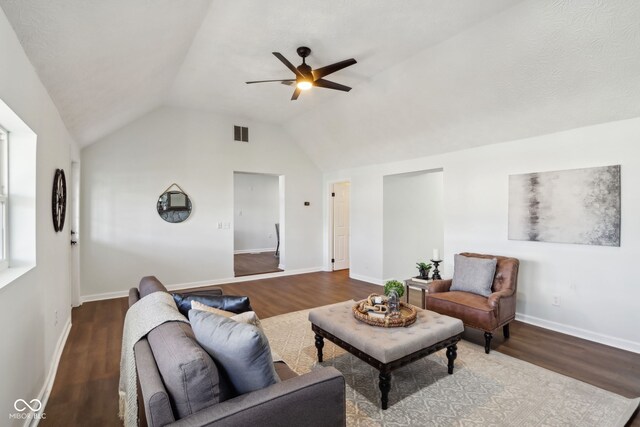 living room with vaulted ceiling, visible vents, baseboards, and wood finished floors