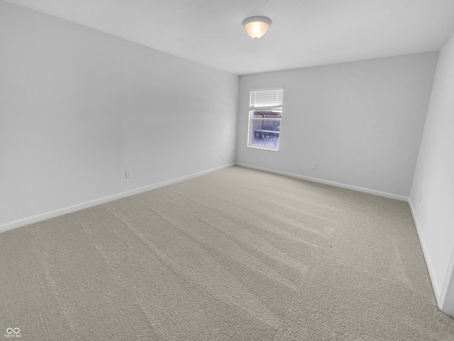 empty room with light colored carpet and baseboards