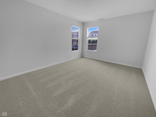 unfurnished room with light carpet and baseboards