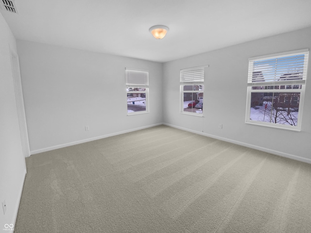 carpeted spare room featuring visible vents and baseboards