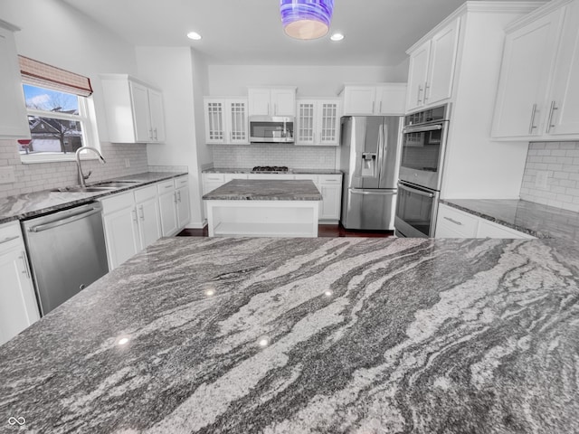 kitchen featuring a sink, glass insert cabinets, appliances with stainless steel finishes, and white cabinets