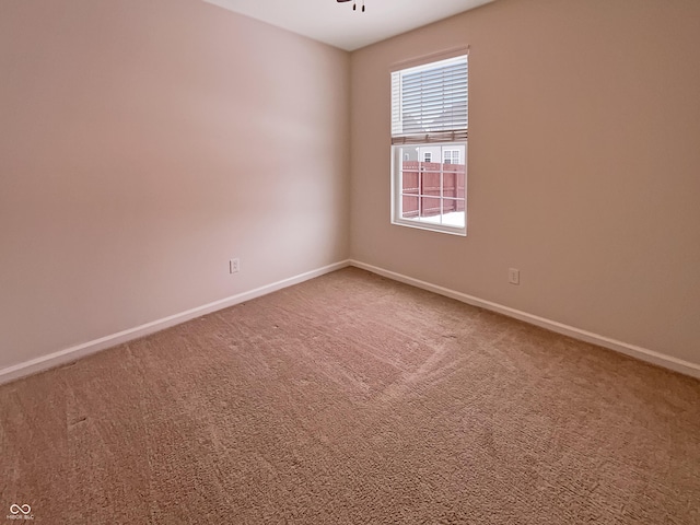 unfurnished room featuring baseboards and carpet