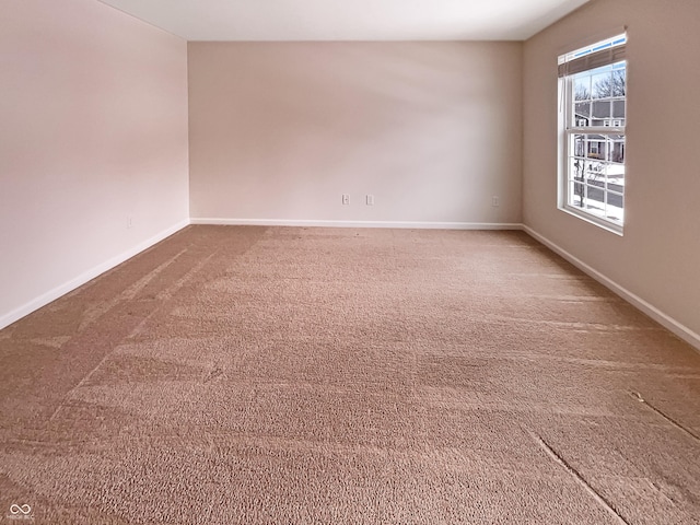 carpeted empty room with baseboards