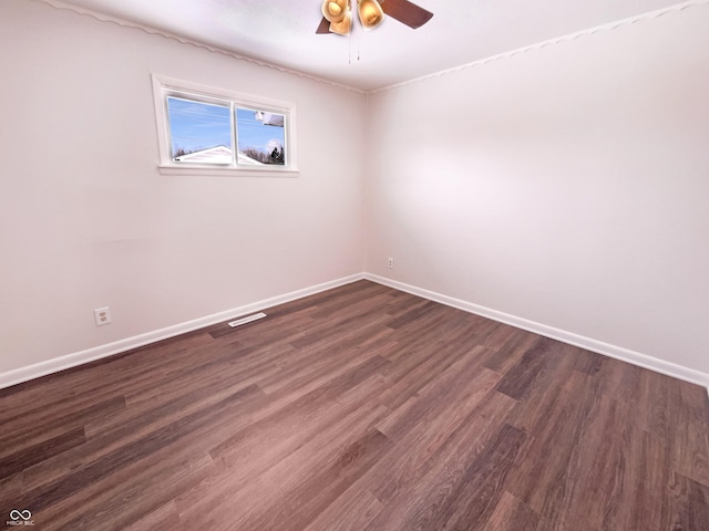 unfurnished room with baseboards, dark wood-style flooring, and ceiling fan