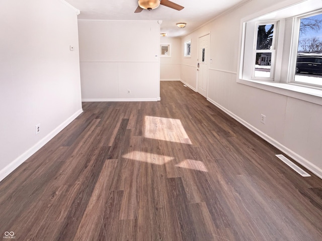 unfurnished room featuring visible vents, wood finished floors, crown molding, baseboards, and ceiling fan