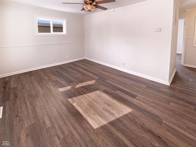 unfurnished room with dark wood finished floors, baseboards, crown molding, and a ceiling fan