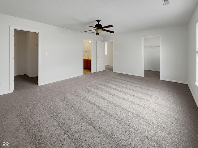 unfurnished bedroom featuring a spacious closet, baseboards, and a closet