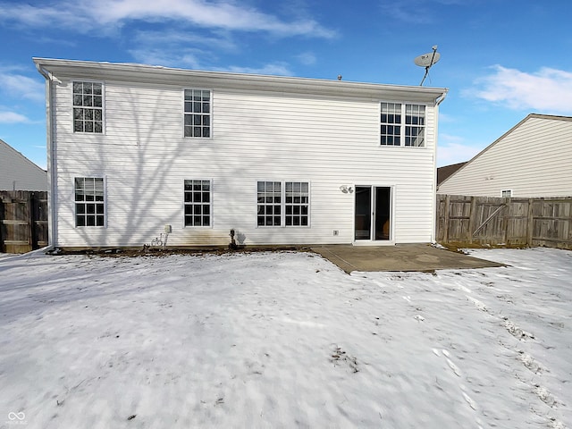 snow covered house with fence