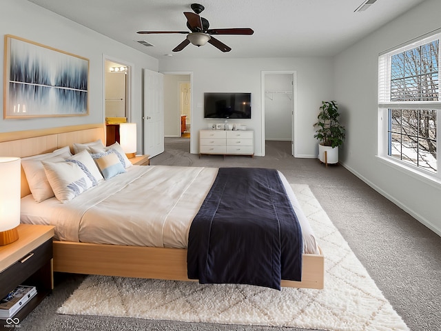 bedroom with a spacious closet, visible vents, ceiling fan, baseboards, and carpet flooring