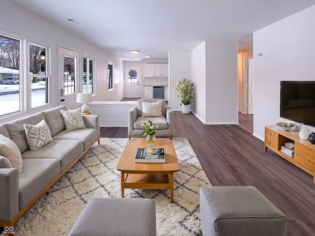 living room featuring wood finished floors, visible vents, and baseboards