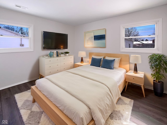 bedroom featuring visible vents, baseboards, and wood finished floors