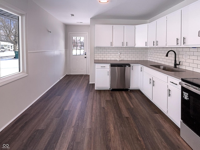 kitchen with dark wood finished floors, electric range, a sink, stainless steel dishwasher, and dark countertops