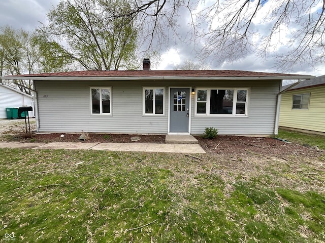 view of front of property featuring a front yard and a chimney