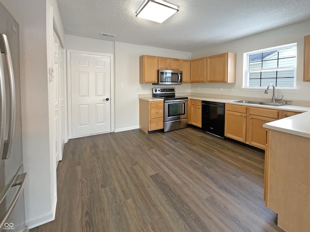 kitchen featuring a sink, stainless steel appliances, visible vents, and dark wood finished floors