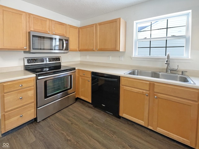 kitchen featuring dark wood finished floors, light brown cabinets, stainless steel appliances, and a sink