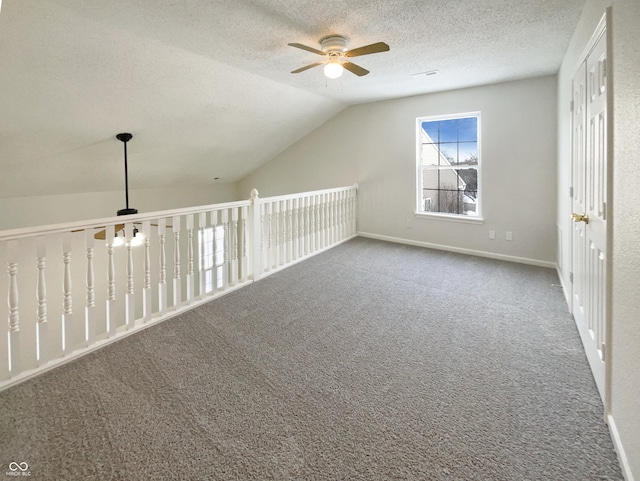 bonus room with carpet, a ceiling fan, baseboards, vaulted ceiling, and a textured ceiling